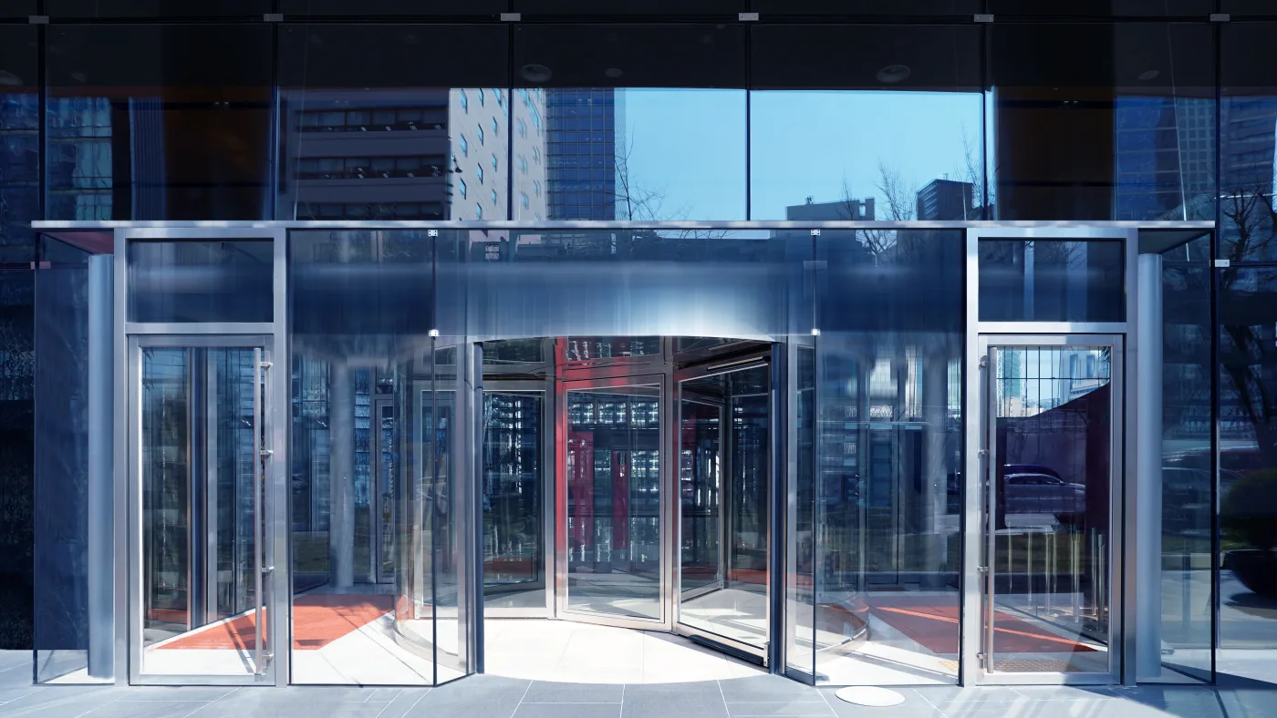 Portes battantes vitrées ouvertes dans le hall d’un immeuble de bureaux
